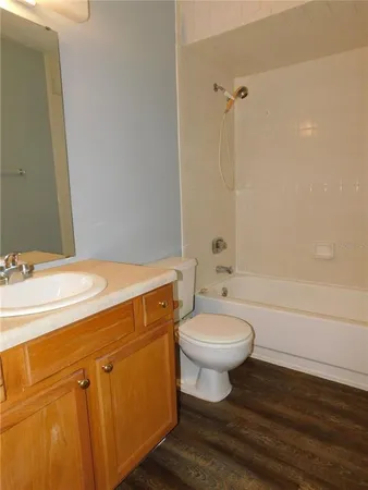 a bathroom with a granite countertop toilet sink and mirror