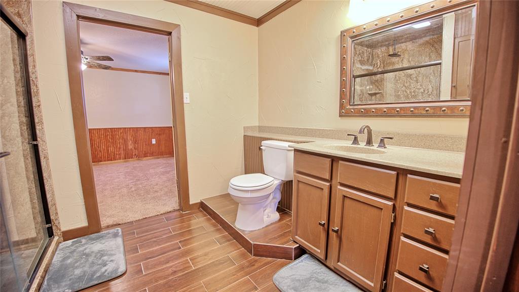 584 West Alamo Road Bowie, TX 76230 - Photo 17 of 40 a bathroom with a sink a toilet and a mirror