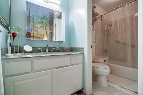 a bathroom with a granite countertop sink toilet and shower