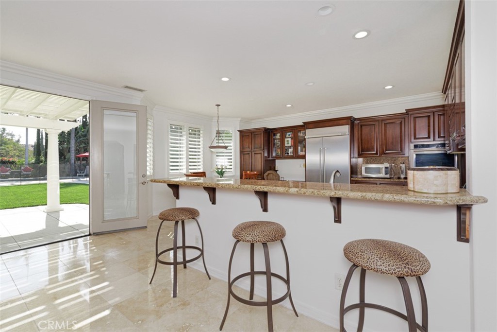 17722 Neff Ranch Road Yorba Linda, CA 92886 - Photo 18 of 63 a kitchen with stainless steel appliances granite countertop a table and chairs in it