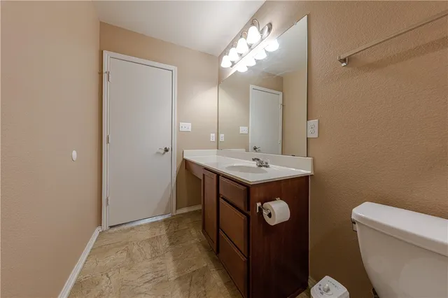 a bathroom with 2 sink toilet and a mirror