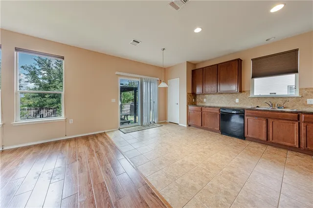 a large kitchen with stainless steel appliances granite countertop a stove a sink and a microwave