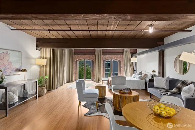 a living room with furniture a fireplace and a dining table with wooden floor