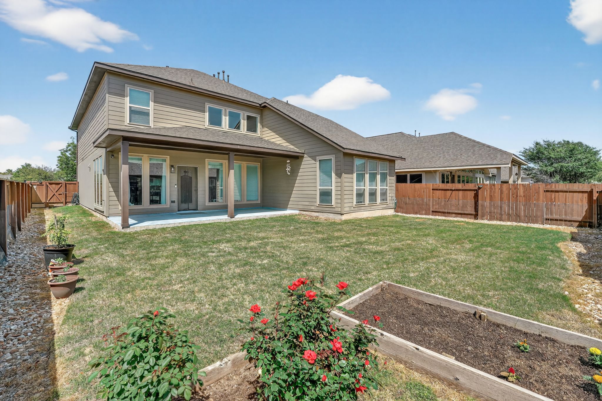 400 Cortona Lane Georgetown, TX 78628 - Photo 4 of 40 Rear view of house featuring a fenced backyard, a garden, a patio, and a shingled roof