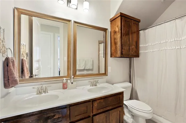 a bathroom with a sink a toilet and a mirror