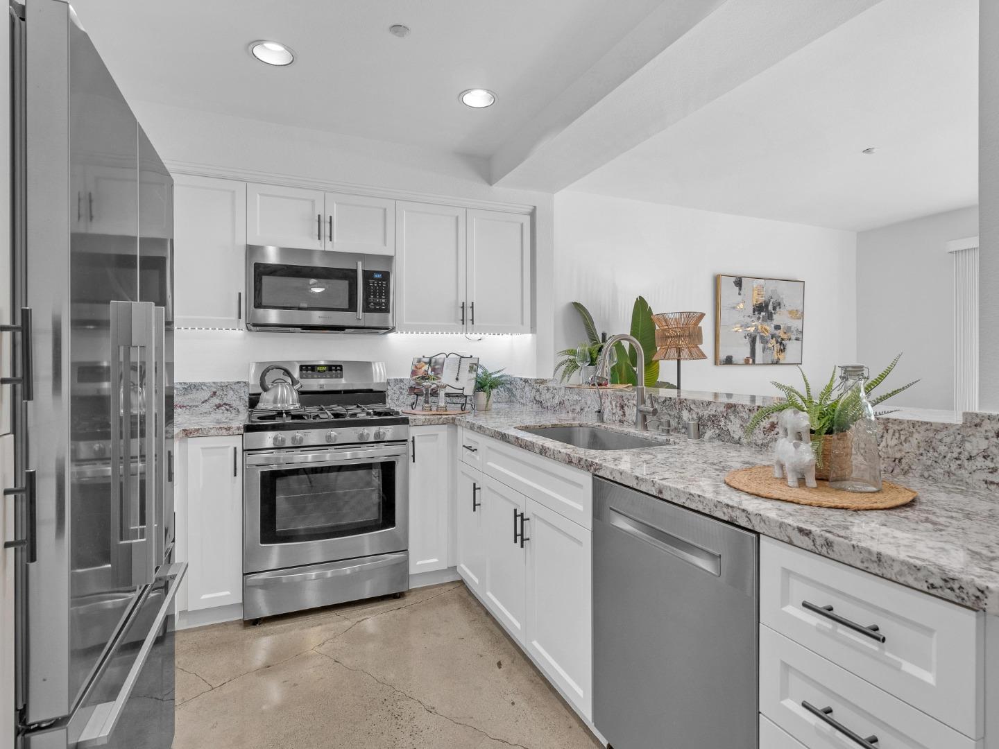 6978 Gregorich Drive, Unit E San Jose, CA 95138 - Photo 11 of 24 a kitchen with granite countertop a sink and stainless steel appliances