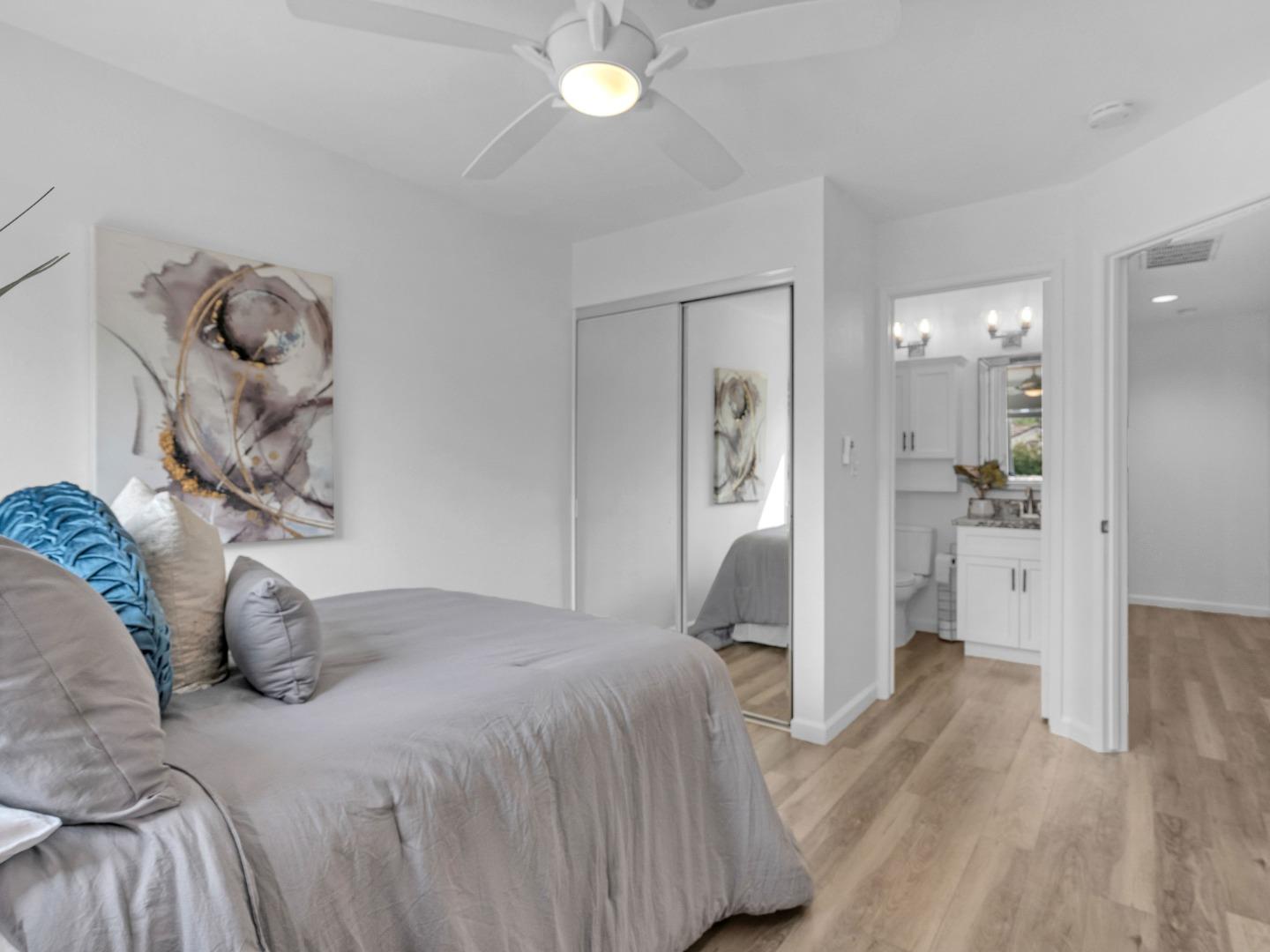 6978 Gregorich Drive, Unit E San Jose, CA 95138 - Photo 15 of 24 a bedroom with a bed and a chandelier