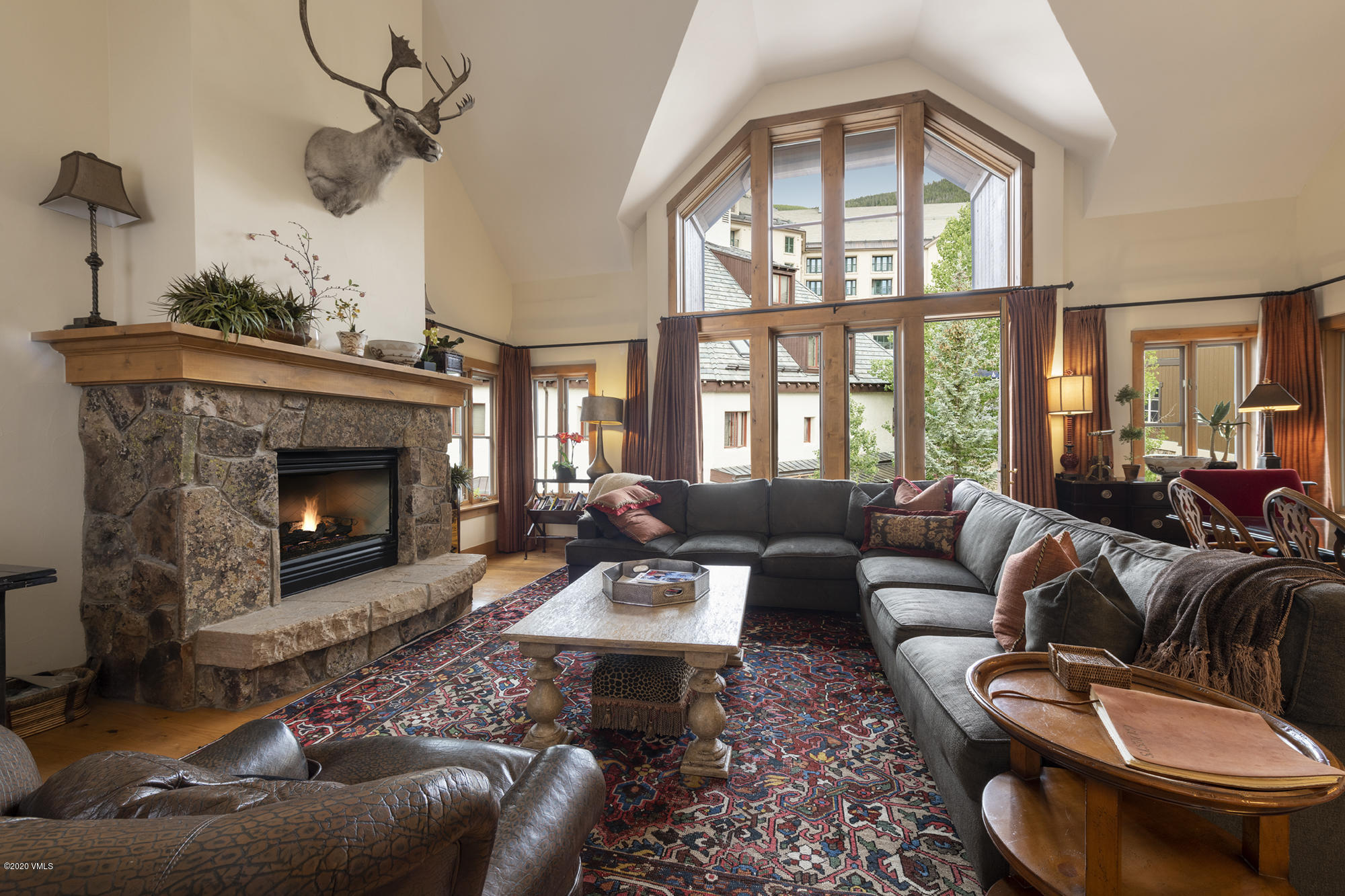 63 Avondale Lane, Unit R215 Beaver Creek, CO 81620 - Photo 2 of 26 a living room with furniture a fireplace and a floor to ceiling window