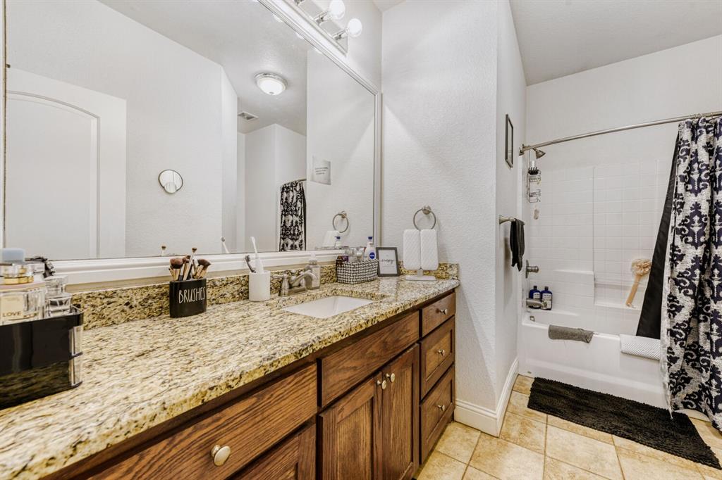 6525 Greenway Road Fort Worth, TX 76116 - Photo 24 of 29 a bathroom with a granite countertop sink a mirror a vanity and shower