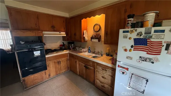 a kitchen with stainless steel appliances a stove a sink and a refrigerator with wooden floor