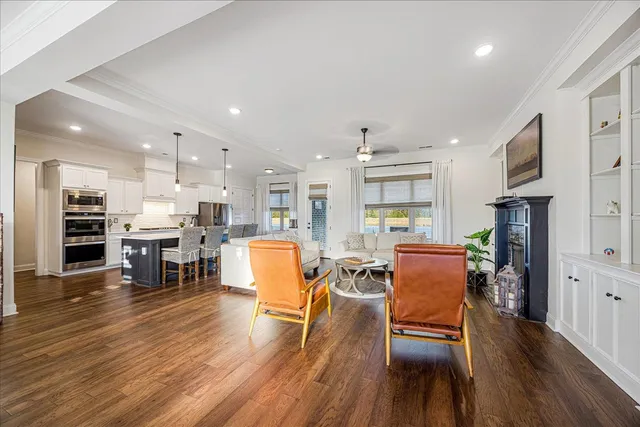 an open kitchen with wooden floor and refrigerator