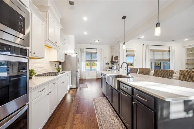 a kitchen with stainless steel appliances granite countertop a sink a stove and a refrigerator