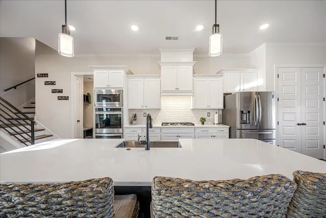 a kitchen with stainless steel appliances kitchen island granite countertop a refrigerator and a stove top oven