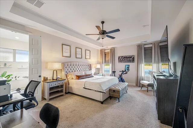 a spacious bedroom with a bed a couch and a chandelier