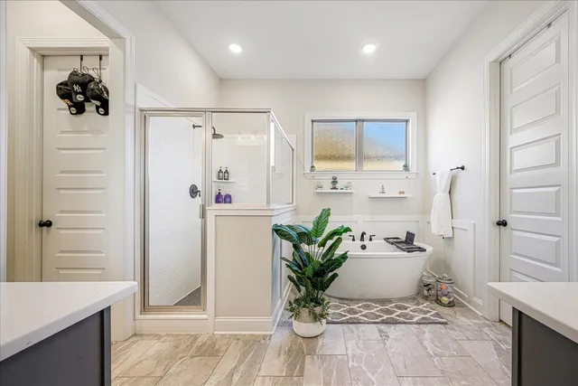 a white bath tub sitting in a bathroom next to a window