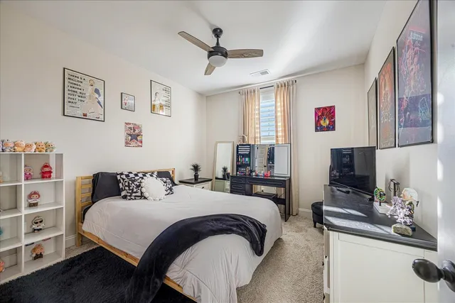 a bedroom with a bed a couch and a ceiling fan