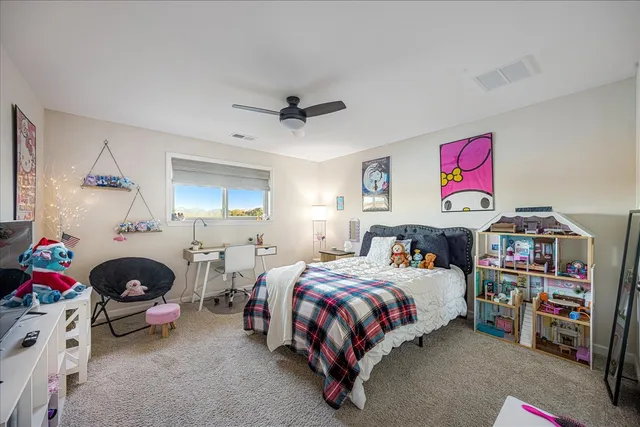 a bedroom with bed a baby bed a couch and a window