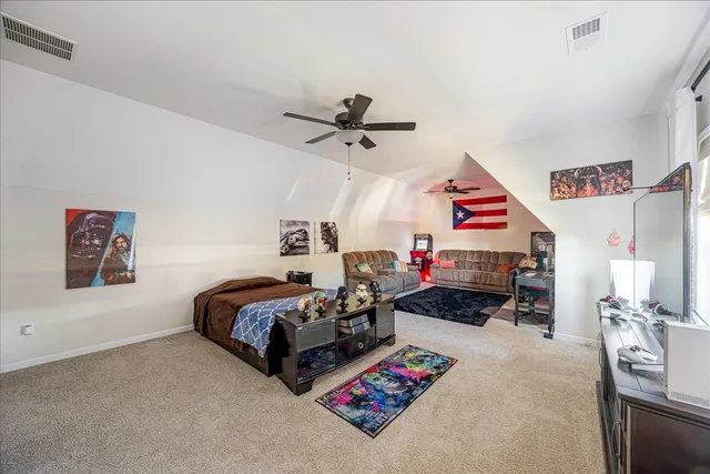 a bed room with bed and a ceiling fan