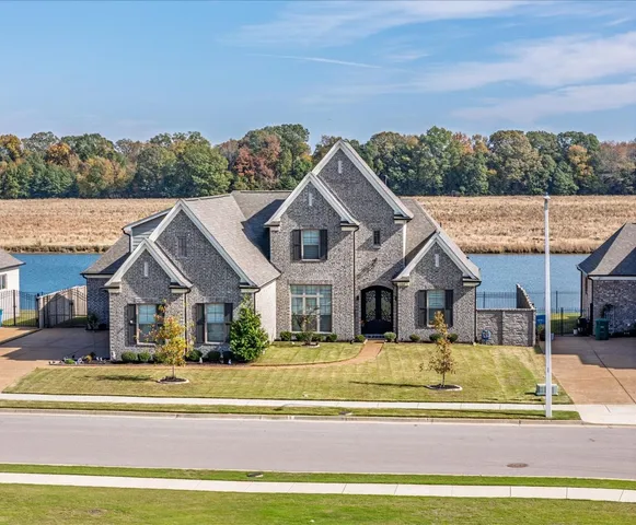 a view of a house with a big yard and large trees