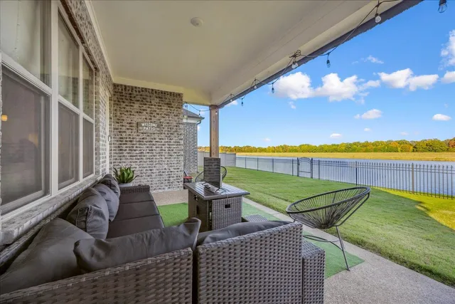 a view of a patio with lawn chairs under an umbrella