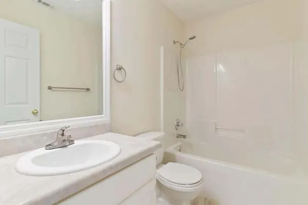 a bathroom with a granite countertop sink a toilet and shower