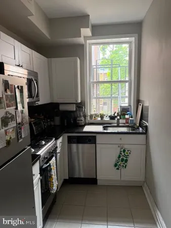 a kitchen with a sink window and cabinets