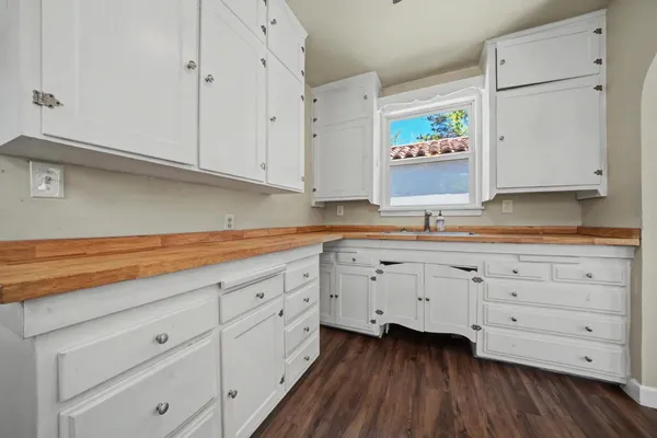 a kitchen with granite countertop white cabinets and white appliances