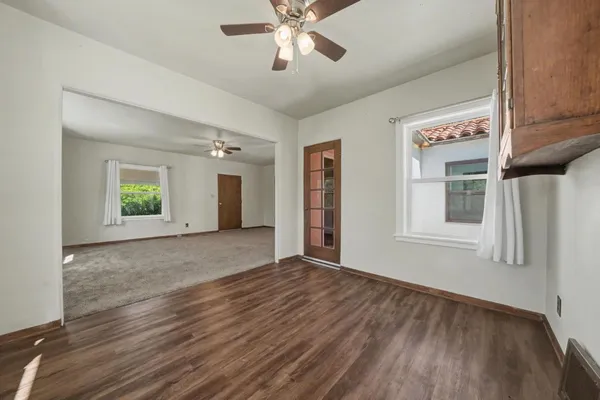 a view of an empty room with window and wooden floor