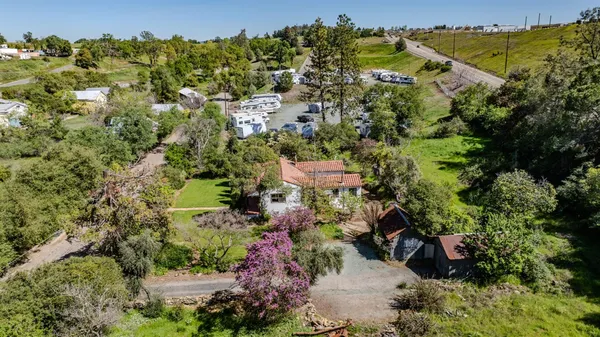 an aerial view of residential house with outdoor space and trees all around
