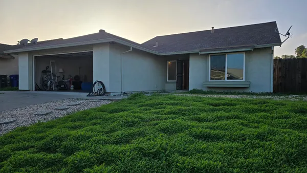 a view of a house with yard and sitting area