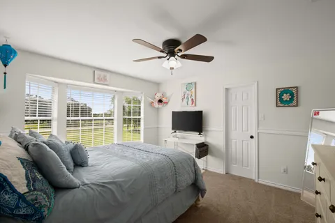 a bedroom with a bed flat screen tv and a window
