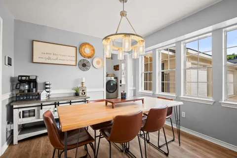 a dining room with wooden floor and a chandelier