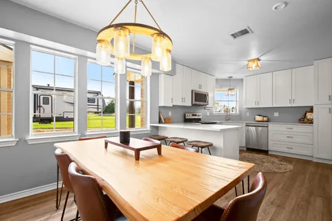 a open kitchen with a table chairs and a chandelier