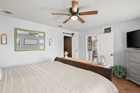 a bedroom with a bed and a flat tv screen on dresser