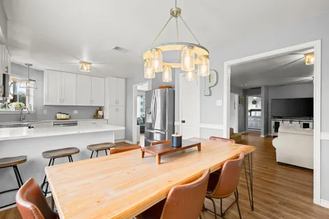 a kitchen with a dining table chairs and white cabinets
