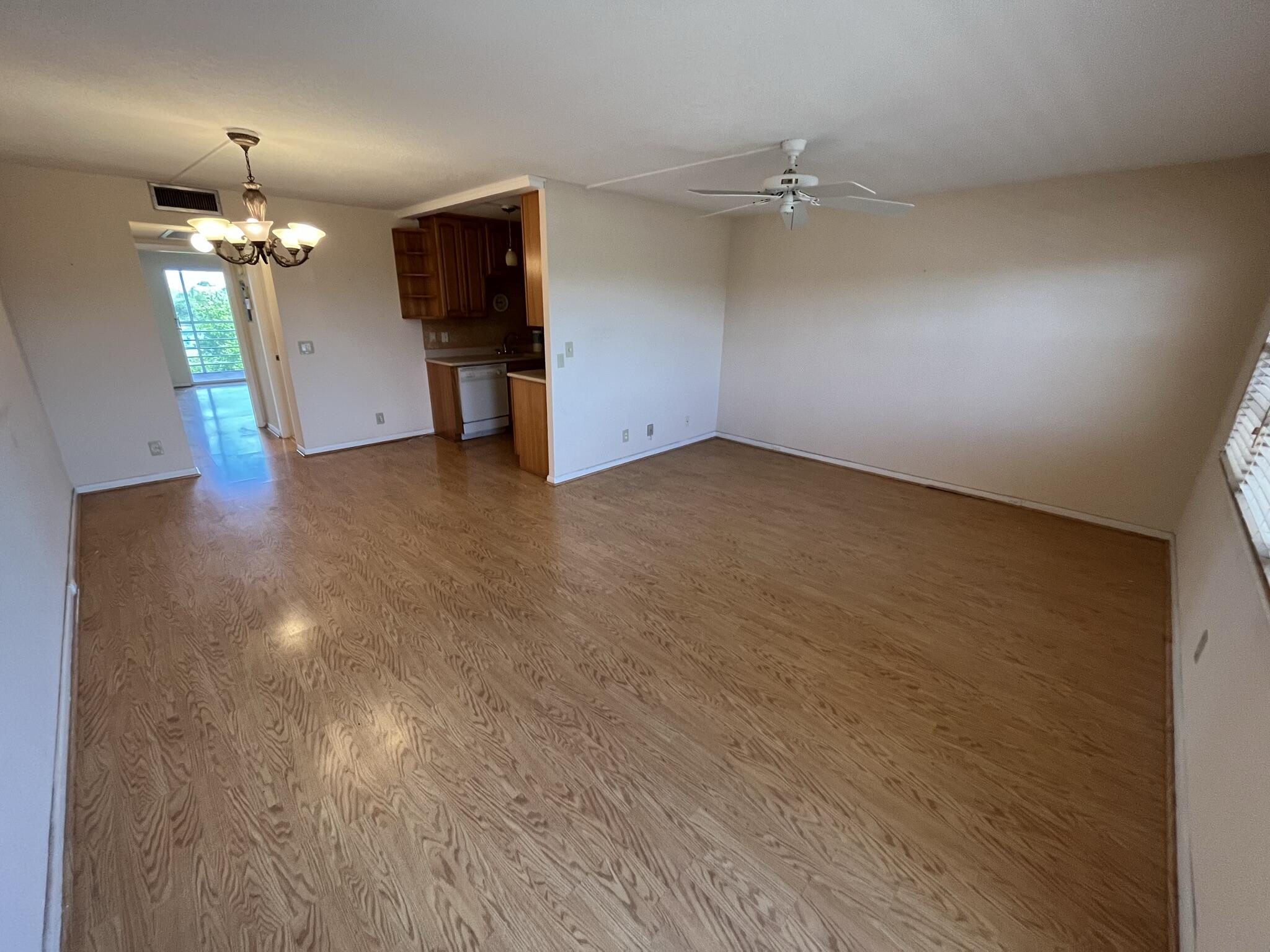 3013 Newcastle A Boca Raton, FL 33434 - Photo 4 of 19 wooden floor in an empty room with a chandelier