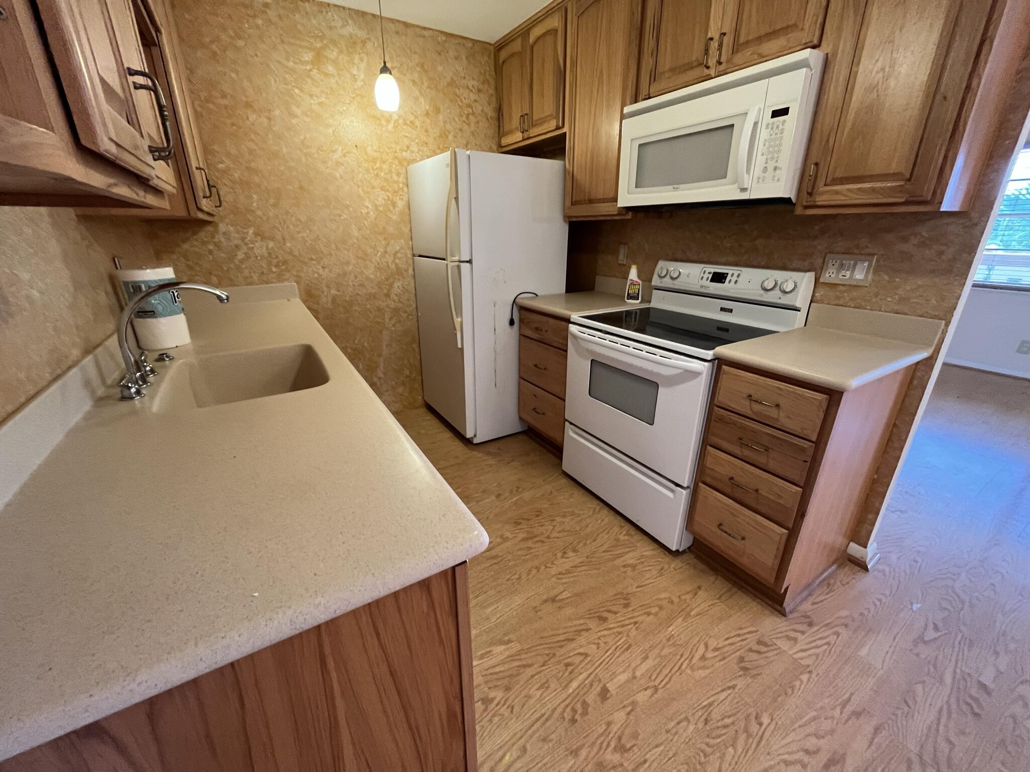 3013 Newcastle A Boca Raton, FL 33434 - Photo 8 of 19 a kitchen with stainless steel appliances a stove a microwave a sink and a refrigerator