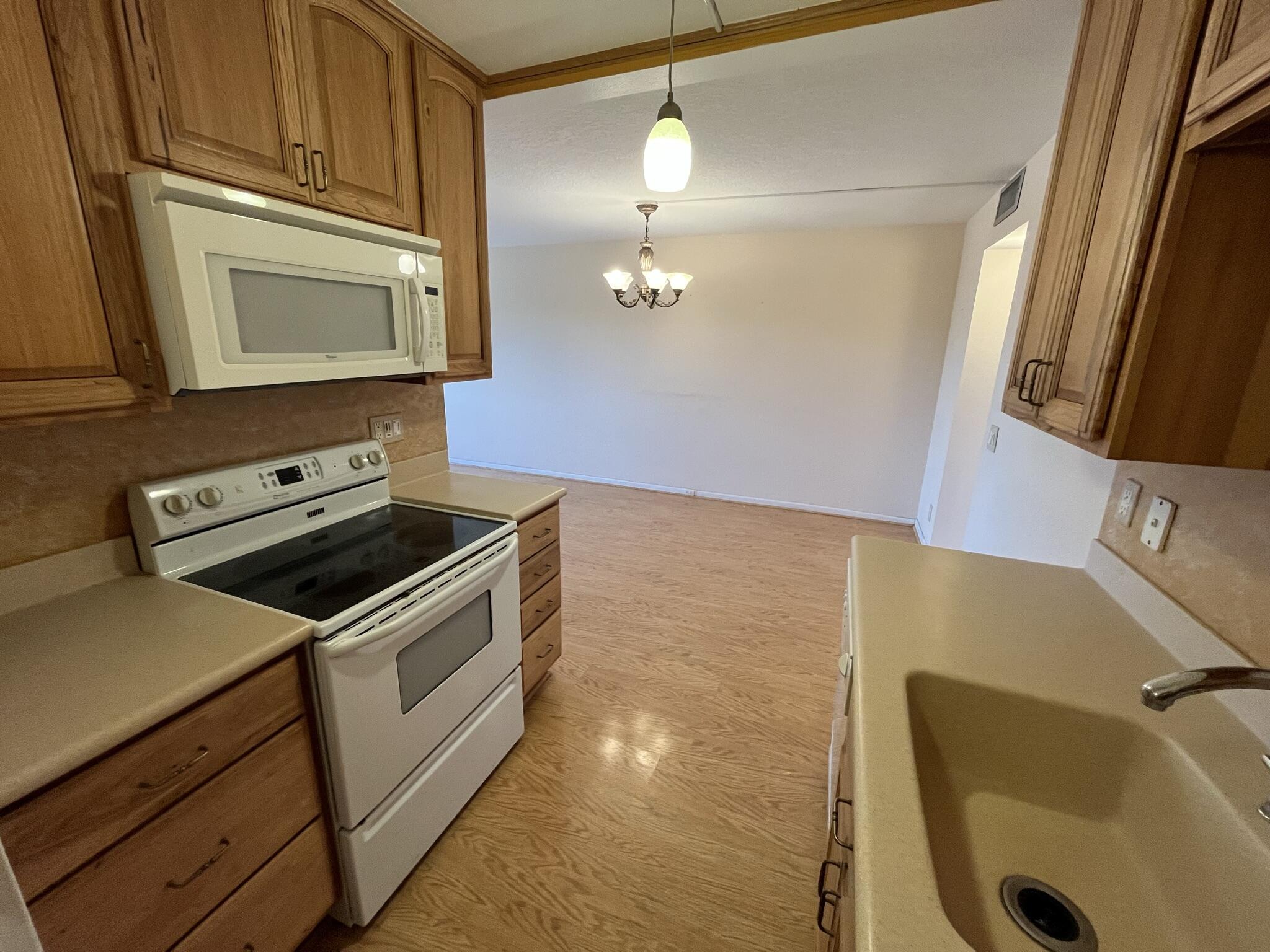 3013 Newcastle A Boca Raton, FL 33434 - Photo 9 of 19 a kitchen with a sink a stove and a microwave oven