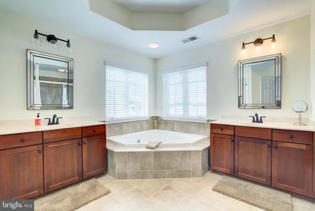 a bathroom with a tub a sink and mirror