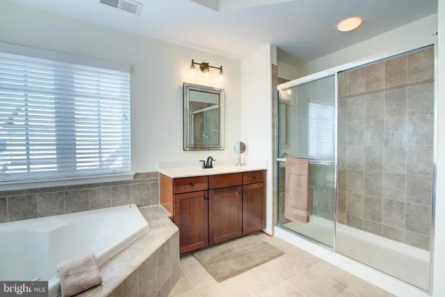 a bathroom with a bathtub sink and mirror