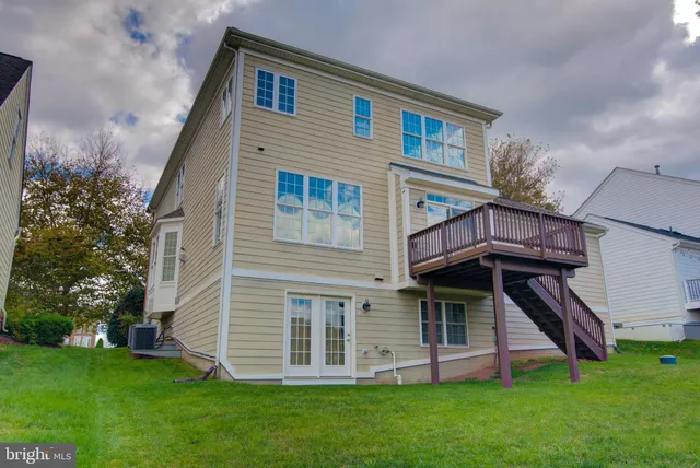 a view of a house with a yard and a wooden deck