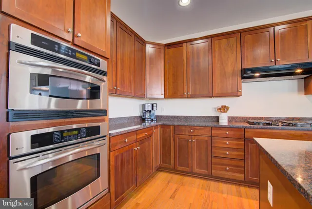 a kitchen with stainless steel appliances granite countertop a stove and cabinets