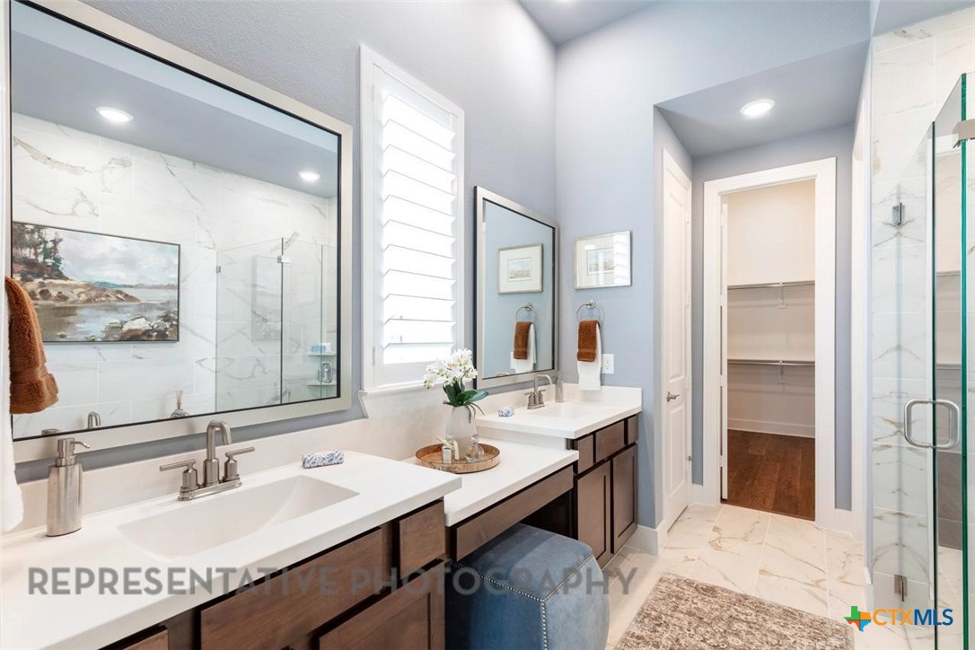 148 Pigeon River Road Kyle, TX 78640 - Photo 20 of 40 a en suite bathroom with a granite countertop sink and a mirror