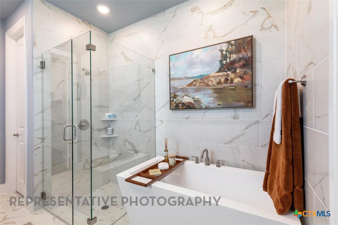 148 Pigeon River Road Kyle, TX 78640 - Photo 21 of 40 a bathroom with a tub and a sink