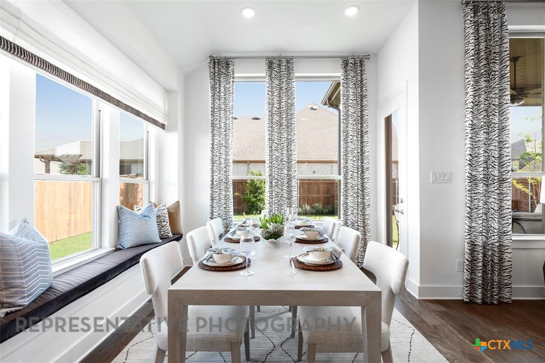 148 Pigeon River Road Kyle, TX 78640 - Photo 26 of 40 a view of a dining room with furniture large windows and wooden floor