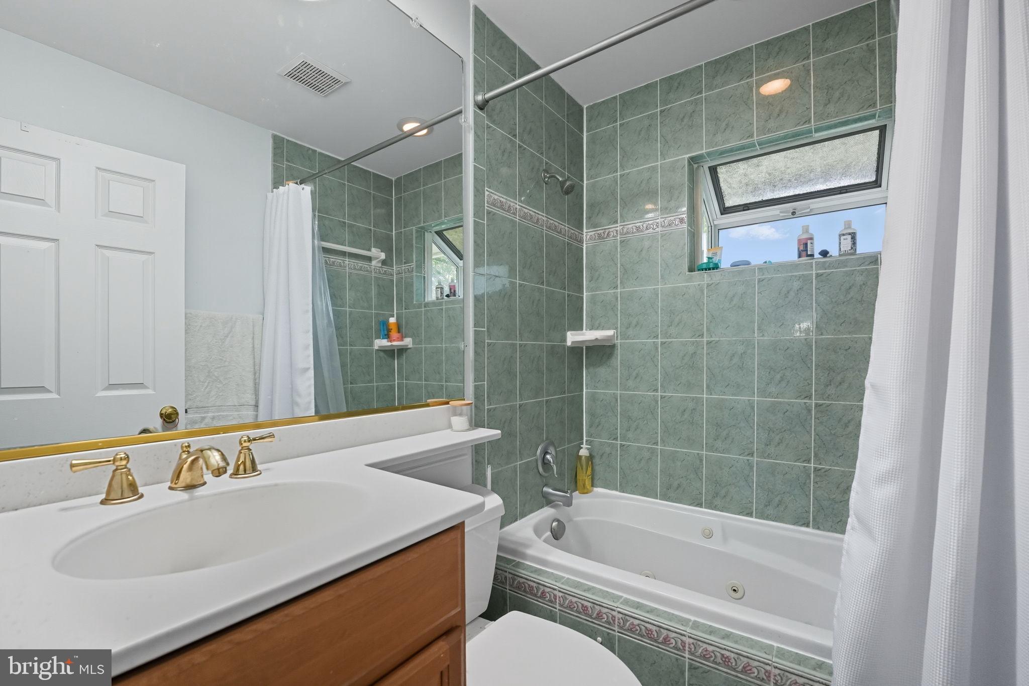 7317 Floyd Avenue Springfield, VA 22150 - Photo 27 of 33 Serene bathroom with elegant green tiles.