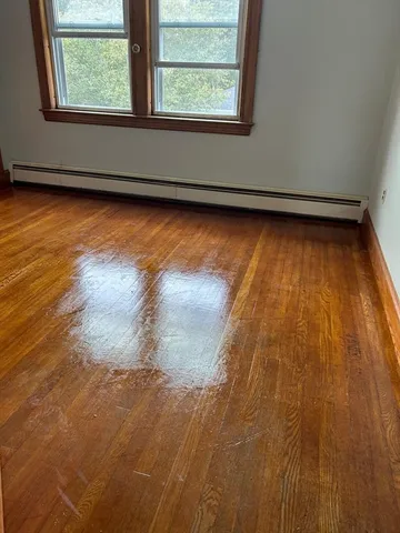 a view of a room with wooden floor and window