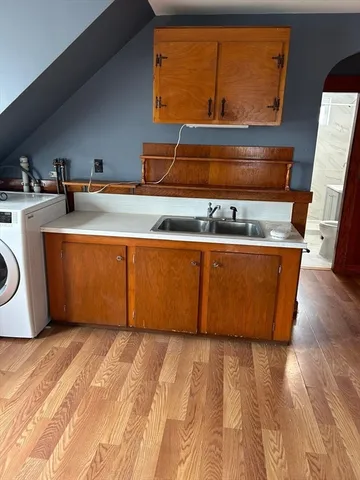 a room with wooden floor and sink