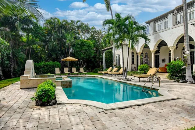 a view of a house with swimming pool and sitting area