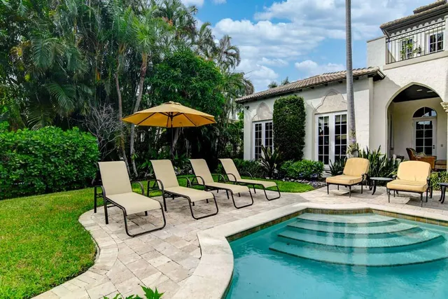 a view of a patio with a table chairs and a small yard